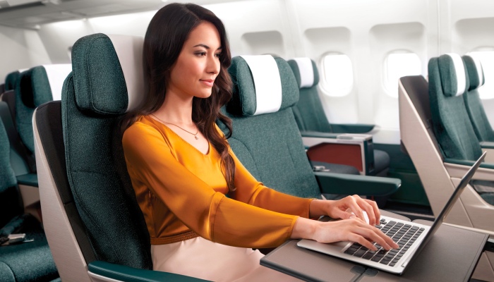 Business email compromise - a female executive works on her PC as she flies